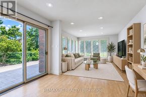 Toronto (Leaside) apartment for rent - A well-lit, modern living room with a sliding glass door leading to a garden.