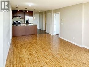 Burnaby apartment for rent - A large open space with wooden floors and a kitchen area.