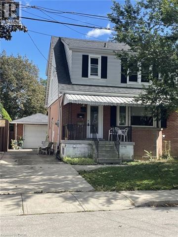Hamilton apartment for rent - A white house with a black roof and a red brick wall.