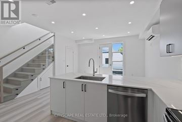 Toronto (Oakwood Village) townhouse for rent - A modern kitchen with a stainless steel dishwasher and white cabinets.