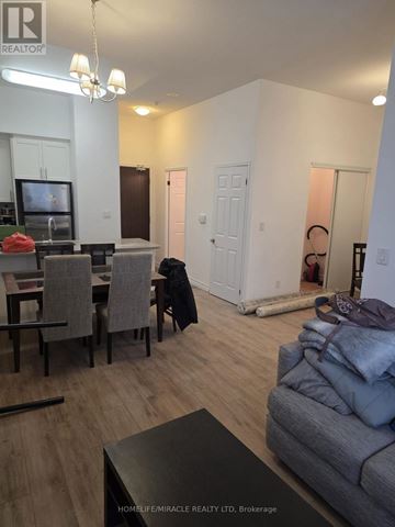 Toronto (Willowdale East) condo for rent - A living room with a grey couch and a dining table with chairs.