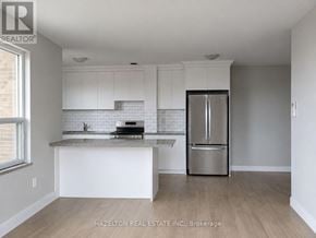 Toronto (Annex) condo for rent - A kitchen with white cabinets and a stainless steel refrigerator.