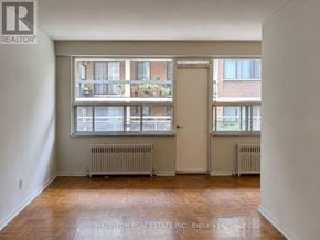 Toronto (Annex) condo for rent - A room with a large window and wooden flooring.