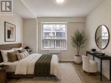 Toronto (Annex) condo for rent - A bedroom with a large bed and a window overlooking a building.