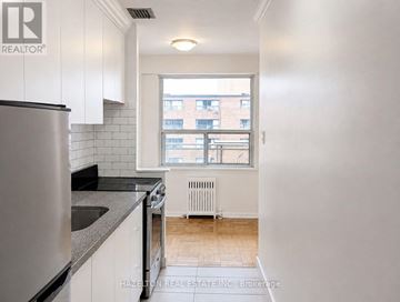 Toronto (Annex) condo for rent - A kitchen with white cabinets and a stainless steel refrigerator.