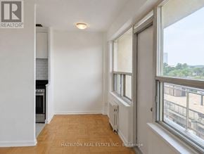 Toronto (Annex) condo for rent - A well-lit, empty room with a window overlooking a balcony.