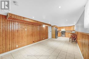 Toronto (West Hill) apartment for rent - A spacious room with wooden walls and a kitchen area in the background.