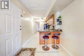 Toronto (Clairlea-Birchmount) townhouse for rent - A well-lit kitchen with bar stools and a refrigerator.