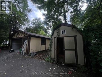 Cornwall apartment for rent - A small building with a door open is surrounded by trees.