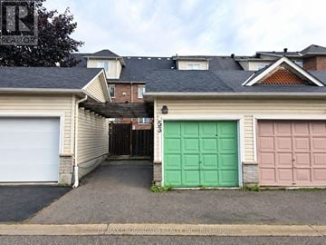 Markham (Cornell) townhouse for rent - A house with a green garage door and a pink garage door.