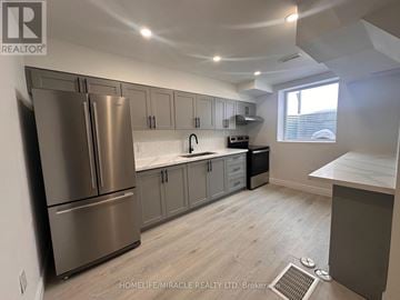 Brampton (Bram East) duplex for rent - A kitchen with a stainless steel refrigerator and a window.