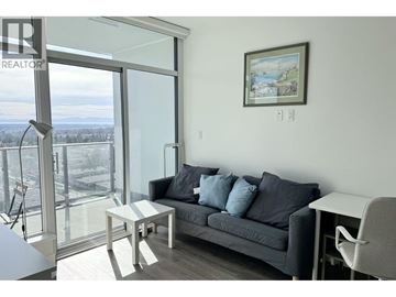 Burnaby apartment for rent - A living room with a grey couch, a small table, and a painting on the wall.