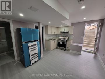Brampton (Credit Valley) apartment for rent - A blue and white refrigerator stands in a kitchen with white cabinets and a marble countertop.