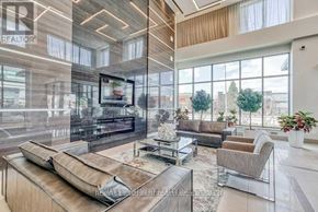 Mississauga (City Centre) condo for rent - A modern living room with a large window overlooking a parking lot.