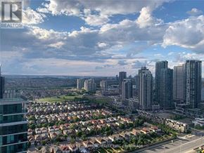 Mississauga (City Centre) condo for rent - A cityscape with a mix of residential and commercial buildings under a partly cloudy sky.