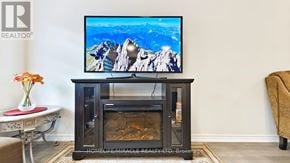 Niagara Falls (Hospital) townhouse for rent - A flat screen TV is on top of a wooden entertainment center.