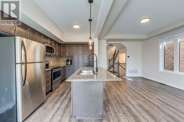 Hamilton (Vincent) apartment for rent - A modern kitchen with a stainless steel refrigerator and wooden flooring.