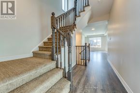 Hamilton (Vincent) apartment for rent - A staircase with a wooden banister and beige carpeted steps leads to a bright room.