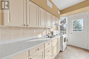 Oshawa (Lakeview) multi-family for rent - A kitchen with white cabinets and a beige countertop.