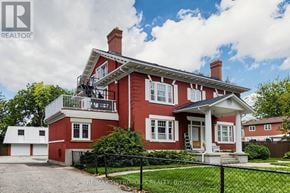 Oshawa (Lakeview) multi-family for rent - A red brick house with a white trim and a black fence in front.