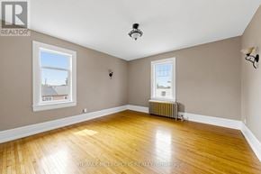 Oshawa (Lakeview) multi-family for rent - A room with wooden floors and a window overlooking a house.