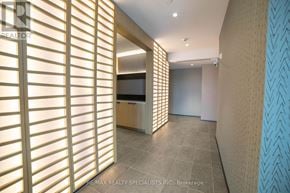 Milton (Cb Cobban) condo for rent - A hallway with a light brown floor and a wall with a patterned blue and white wallpaper.