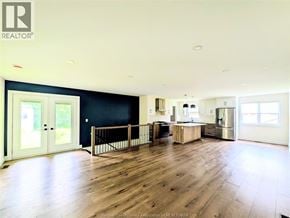 Windsor apartment for rent - A spacious living room with wooden floors and a kitchen area in the background.