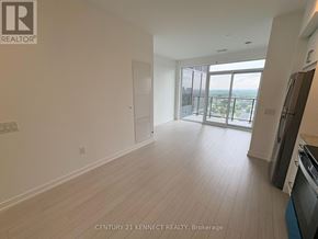 Toronto (Humber Heights) condo for rent - A spacious room with a kitchen area and a view of the city.