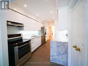 Toronto (Kensington-Chinatown) townhouse for rent - A modern kitchen with white cabinets and a stainless steel oven.