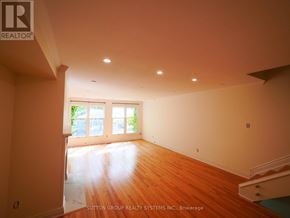 Toronto (Kensington-Chinatown) townhouse for rent - A room with wooden floors and a large window.