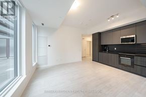 Toronto (Waterfront Communities) condo for rent - A spacious, modern kitchen with dark wood cabinets and a stainless steel oven.