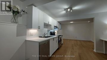 Georgina (Keswick South) apartment for rent - A kitchen with white cabinets and a wooden floor.