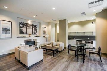 Surrey apartment for rent - A modern living room with a fireplace and a dining table.