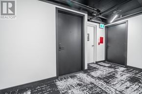 Hamilton (Beasley) condo for rent - A hallway with a black door and a red fire extinguisher.