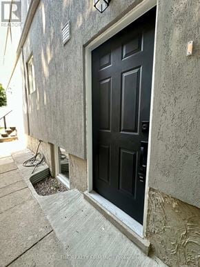 Toronto (Rockcliffe-Smythe) duplex for rent - A black door is set in a concrete wall.
