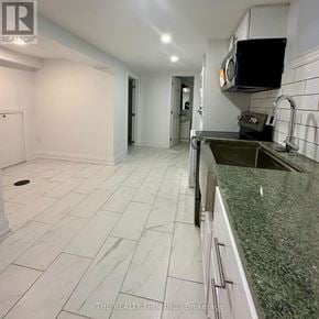 Toronto (Rockcliffe-Smythe) duplex for rent - A kitchen with white tiled floors and a green granite countertop.