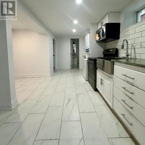 Toronto (Rockcliffe-Smythe) duplex for rent - A kitchen with white cabinets and a black stove top oven.