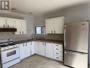 Georgina (Keswick South) apartment for rent - A kitchen with white cabinets and a stainless steel refrigerator.
