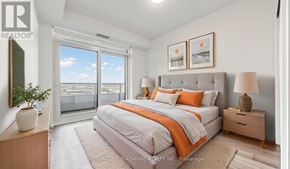 Vaughan (Vaughan Corporate Centre) condo for rent - A bedroom with a large bed and a view of the city.