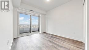 Vaughan (Vaughan Corporate Centre) condo for rent - A room with a large window and wooden flooring.