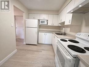 Ottawa townhouse for rent - A kitchen with white appliances and cabinets.