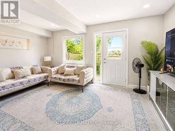 Ottawa townhouse for rent - A living room with a white couch and a blue patterned rug.