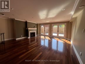Toronto (Yonge-St. Clair) apartment for rent - A spacious room with wooden floors and a fireplace.