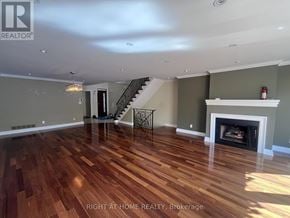 Toronto (Yonge-St. Clair) apartment for rent - A spacious room with wood flooring and a staircase.