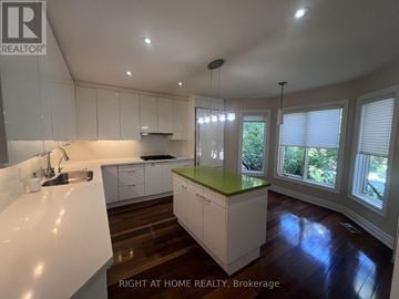 Toronto (Yonge-St. Clair) apartment for rent - A kitchen with white cabinets and a green island.