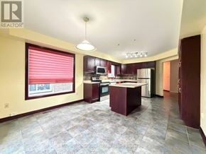 Guelph (Pineridge/Westminster Woods) apartment for rent - A spacious kitchen with a large island and a window with red blinds.