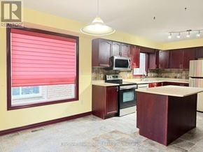 Guelph (Pineridge/Westminster Woods) apartment for rent - A kitchen with a red countertop and a stove top oven.