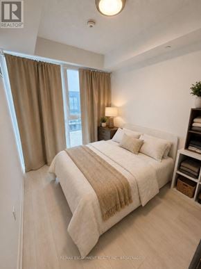 Burlington (Lasalle) condo for rent - A bedroom with a bed, nightstand, and window with curtains.