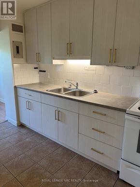 Niagara Falls (Dorchester) multi-family for rent - A kitchen with white cabinets and a white dishwasher.