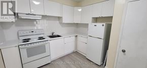 Toronto (Bedford Park-Nortown) apartment for rent - A white kitchen with a stove, sink, and refrigerator.